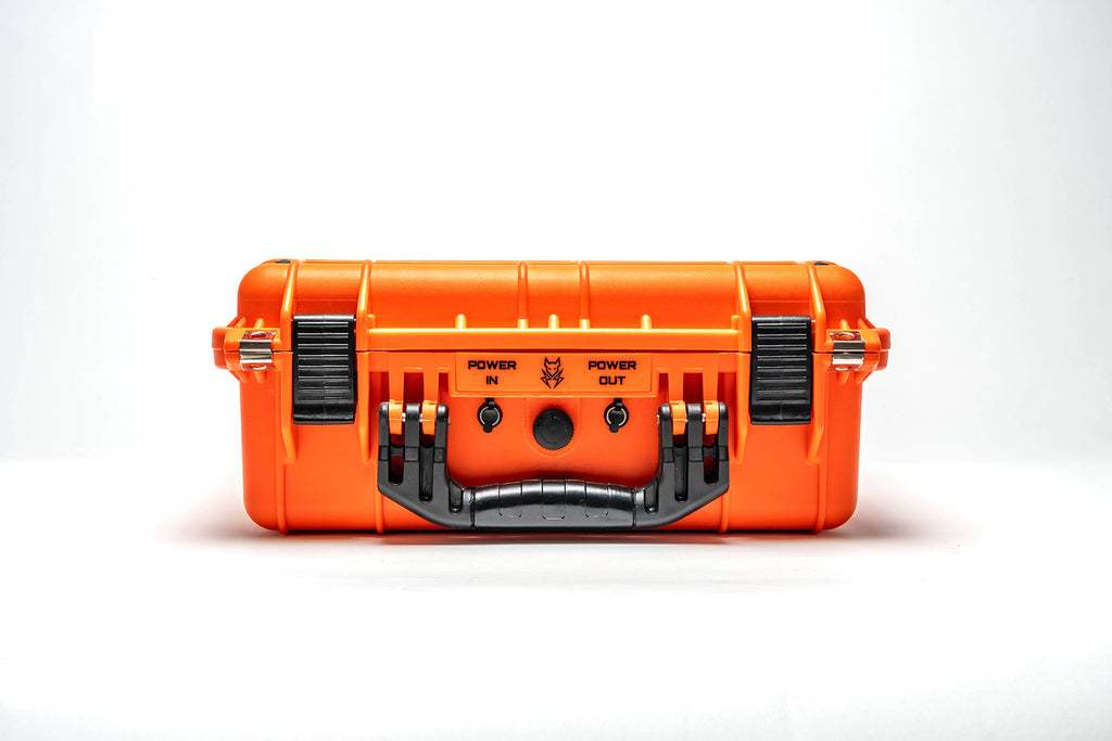 An orange hard-shell power station or portable battery case shown from the back, featuring black latches, a black handle, and power input/output terminals, set against a plain white background.